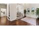 Elegant foyer with hardwood floors, staircase, and view into the dining room with chandelier at 11441 Hammock Oaks Ct, Lithia, FL 33547