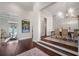 Elegant foyer with hardwood floors, staircase, and view into the dining room with chandelier at 11441 Hammock Oaks Ct, Lithia, FL 33547