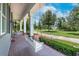 Inviting front porch featuring a white swing and brick flooring, offering a relaxing outdoor space at 11441 Hammock Oaks Ct, Lithia, FL 33547