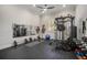 Spacious home gym with weightlifting equipment, mirrored wall, and rubber flooring at 11441 Hammock Oaks Ct, Lithia, FL 33547