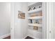 Hallway featuring built-in shelving displaying decorative items and unique wall art at 11441 Hammock Oaks Ct, Lithia, FL 33547