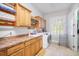 Functional laundry room boasts ample cabinet space, countertops, and modern washer and dryer at 11441 Hammock Oaks Ct, Lithia, FL 33547