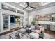 A contemporary living room featuring a gray sofa, wet bar, and view of a luxury outdoor space at 11441 Hammock Oaks Ct, Lithia, FL 33547