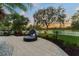 Inviting backyard patio featuring a cozy daybed, lush landscaping, and views of the well-manicured golf course at 11441 Hammock Oaks Ct, Lithia, FL 33547