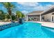 Resort-style pool area with waterfall feature, patio furniture, and a covered outdoor kitchen at 11441 Hammock Oaks Ct, Lithia, FL 33547