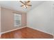 Neutral bedroom with hardwood floors, ceiling fan, and window providing natural light at 11620 Crest Creek Dr, Riverview, FL 33569
