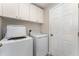 Functional laundry room with a washer, dryer, and overhead storage cabinets for supplies at 11620 Crest Creek Dr, Riverview, FL 33569