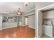 Open-concept living space featuring hardwood floors, neutral paint, and a view into the kitchen and laundry area at 11620 Crest Creek Dr, Riverview, FL 33569