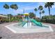 The splash pad features a slide and various water features, surrounded by comfortable seating and shade at 11620 Crest Creek Dr, Riverview, FL 33569