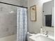 Stylish bathroom featuring marble-look tile, a floral shower curtain, and modern fixtures at 12231 Kirk Ave, Port Charlotte, FL 33981