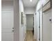 Bright hallway with white walls, trim, and doors, leading to various rooms with hardwood flooring at 12231 Kirk Ave, Port Charlotte, FL 33981