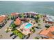 Stunning aerial view of the community pool, clubhouse and waterfront homes overlooking the serene bay waters at 128 1St Street E. # 102, Tierra Verde, FL 33715