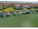 Scenic aerial view of condos with red tile roofs, lush greenery, and a marina at 128 1St Street E. # 102, Tierra Verde, FL 33715