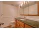 Bathroom featuring a wood vanity with granite countertop, blending classic style with modern convenience at 128 1St Street E. # 102, Tierra Verde, FL 33715