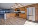 Open kitchen featuring wood cabinets, stainless steel appliances, and tile flooring at 128 1St Street E. # 102, Tierra Verde, FL 33715