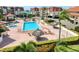Aerial view of a sparkling pool area, showcasing tiki umbrellas and the inviting community space at 128 1St Street E. # 102, Tierra Verde, FL 33715