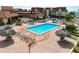 Aerial view of community pool, lounge area, and seating with umbrellas at 128 1St Street E. # 102, Tierra Verde, FL 33715