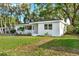 Charming single-story home with white exterior, well-maintained lawn and mature trees at 1352 Parkwood St, Clearwater, FL 33755