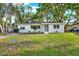 Charming single-story home featuring a manicured lawn and fresh landscaping, painted in white at 1352 Parkwood St, Clearwater, FL 33755