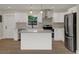 Modern kitchen with stainless steel appliances, island, white cabinets, and stylish pendant lighting at 1352 Parkwood St, Clearwater, FL 33755