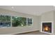 Living room featuring hardwood floors, a modern fireplace, and large windows overlooking greenery at 1352 Parkwood St, Clearwater, FL 33755