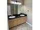 Bathroom featuring a double sink vanity with black granite countertop and tile floors at 13632 Deventer Ct., Hudson, FL 34667