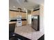 Kitchen featuring granite countertops, wood cabinets, stainless steel fridge, and tile flooring at 13632 Deventer Ct., Hudson, FL 34667