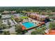 Aerial view featuring community pool, playground, tennis courts, and colorful condo buildings at 13941 Clubhouse Dr # 308, Tampa, FL 33618