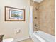 Bathroom with a bathtub/shower, neutral tile, and decorative framed art in a calming design at 13941 Clubhouse Dr # 308, Tampa, FL 33618