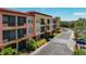 Exterior view showcasing condo building with screened balconies and lush landscaping along the street at 13941 Clubhouse Dr # 308, Tampa, FL 33618