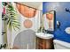 Bright blue bathroom featuring a stylish vanity, sink, mirror and a shower with a unique modern patterned shower curtain at 1420 W Rambla St, Tampa, FL 33612
