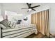 Bedroom featuring a modern ceiling fan and a queen bed with a striped comforter and curtained closet at 1420 W Rambla St, Tampa, FL 33612