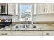 Close-up of granite countertop and stainless sink with modern faucet, framed by white cabinets at 1420 W Rambla St, Tampa, FL 33612