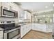 Updated kitchen with stainless steel appliances, white cabinetry, and granite countertops at 1420 W Rambla St, Tampa, FL 33612