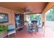 Relaxing covered patio with ceiling fan, table set, and views of the fenced backyard at 1512 W Sitka St, Tampa, FL 33604