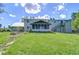 Expansive backyard with a screened-in porch, lush green lawn, and staircase access at 16930 Sweetwater Rd, Dade City, FL 33523