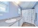 Bathroom features a vanity with granite countertop, shower, and window at 16930 Sweetwater Rd, Dade City, FL 33523