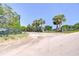 Gated entrance with palm trees, leading to a charming property with a scenic view of the land at 16930 Sweetwater Rd, Dade City, FL 33523