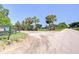 Gated entrance with palm trees, leading to a charming property with a scenic view of the land at 16930 Sweetwater Rd, Dade City, FL 33523