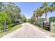 Gravel driveway leading to a charming home with lush landscaping and plenty of curb appeal at 16930 Sweetwater Rd, Dade City, FL 33523