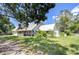 Well-maintained green home featuring a durable metal roof and a welcoming covered front porch at 16930 Sweetwater Rd, Dade City, FL 33523
