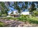 Well-maintained green home featuring a durable metal roof and a welcoming covered front porch at 16930 Sweetwater Rd, Dade City, FL 33523