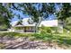 Well-maintained green home featuring a durable metal roof and a welcoming covered front porch at 16930 Sweetwater Rd, Dade City, FL 33523