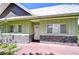 Welcoming home entrance with light green siding, stone accents, and a white front door at 16930 Sweetwater Rd, Dade City, FL 33523