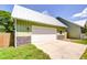 Detached garage with a white door, metal roof, and stylish stone veneer accents at 16930 Sweetwater Rd, Dade City, FL 33523
