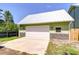 Detached garage with a white door, metal roof, and stylish stone veneer accents at 16930 Sweetwater Rd, Dade City, FL 33523