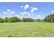 Vast, lush grassy field stretching towards the horizon under a clear, blue sky, beautiful acreage for sale at 16930 Sweetwater Rd, Dade City, FL 33523