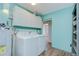 Bright laundry room featuring a washer and dryer, cabinets, and view to another room at 16930 Sweetwater Rd, Dade City, FL 33523