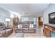 Bright living room featuring wood floors, a ceiling fan, and a comfortable leather sofa at 16930 Sweetwater Rd, Dade City, FL 33523
