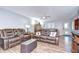 Spacious living room featuring comfortable leather seating, ceiling fan, and natural lighting at 16930 Sweetwater Rd, Dade City, FL 33523